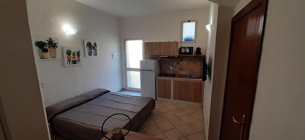 Una pequeña habitación con una cama y una cocina. en Casa Roberto, en Arzachena