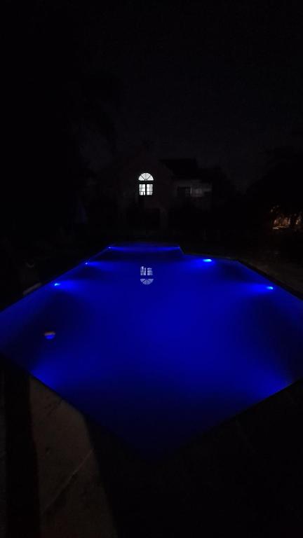 una piscina azul en la oscuridad con una ventana en Casa Necha en Vaqueros