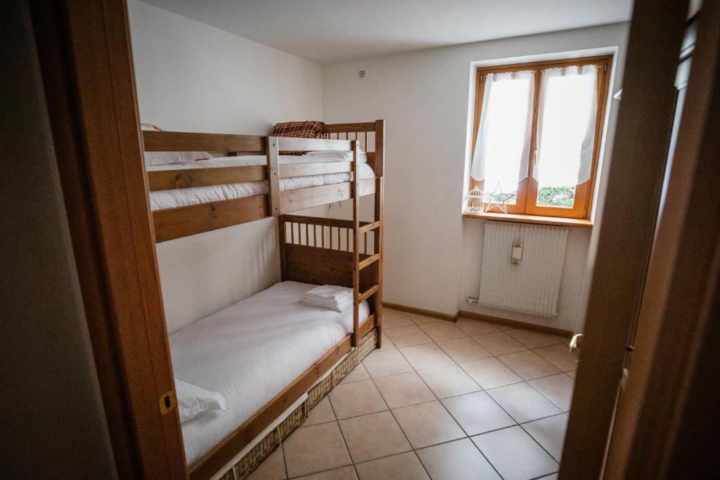 um quarto com 2 beliches e uma janela em Appartamento il Cervo em Fai della Paganella