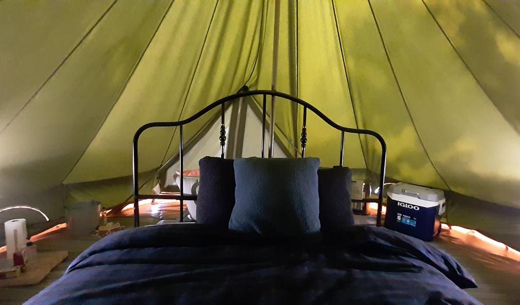 a bedroom with a bed in a tent at Elevated Experience Camping Inc. Willey West in Drayton Valley
