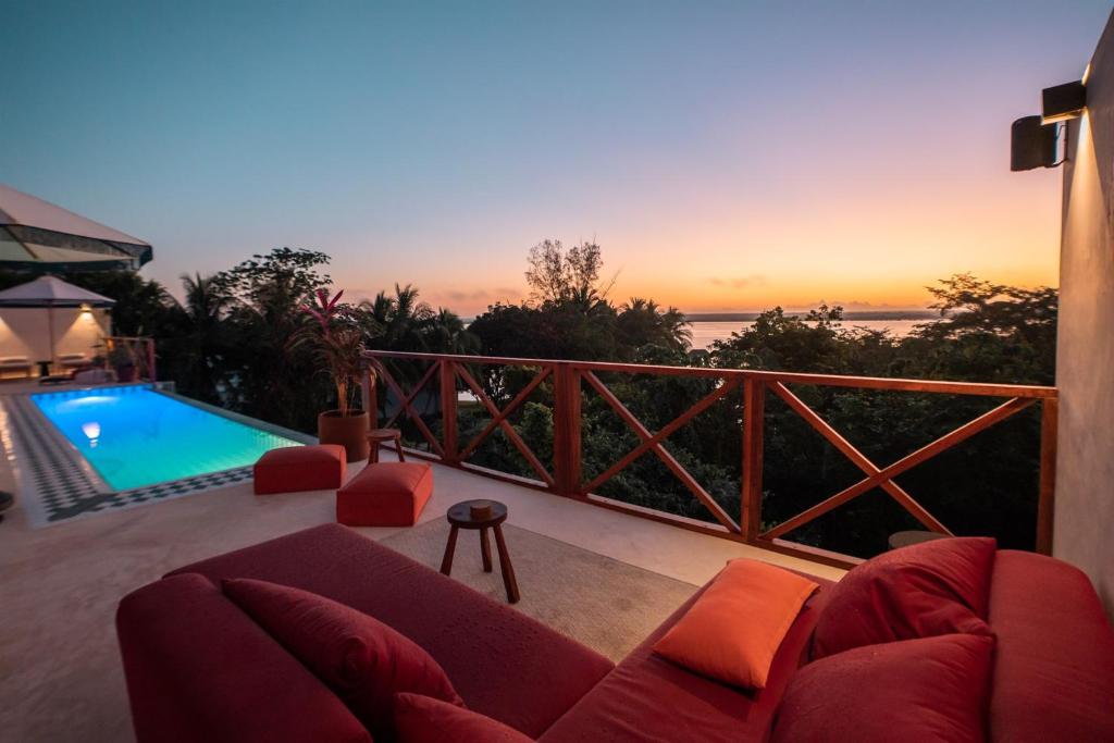 a living room with a couch and a swimming pool at Bacalari - Adults Only in Bacalar