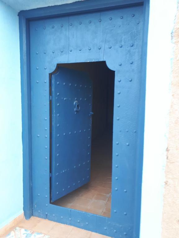 Una puerta azul en una habitación con espejo en Chez Meriem, en Merzouga