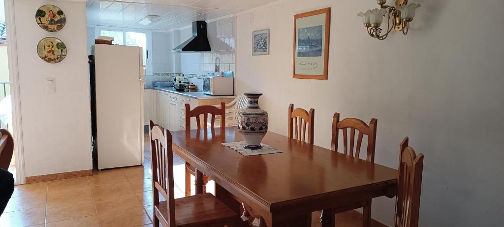 cocina con mesa de madera con sillas y nevera en Casa Dolors, en Ossó de Sió