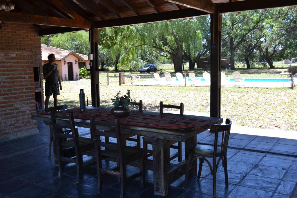 una mesa de madera y sillas sentadas bajo un pabellón en Casa Del Molino, Casa de Campo, Cañuelas en Cañuelas