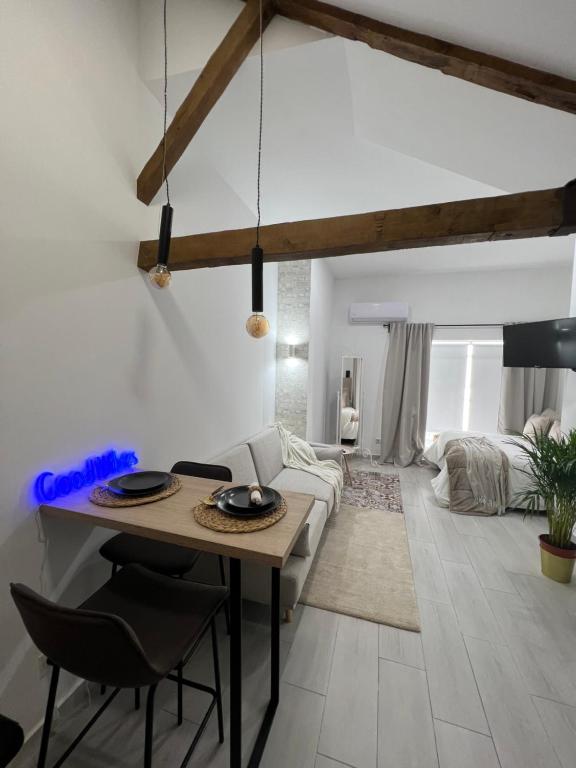 uma sala de estar com uma mesa e um sofá em Suites Chic em Herencia