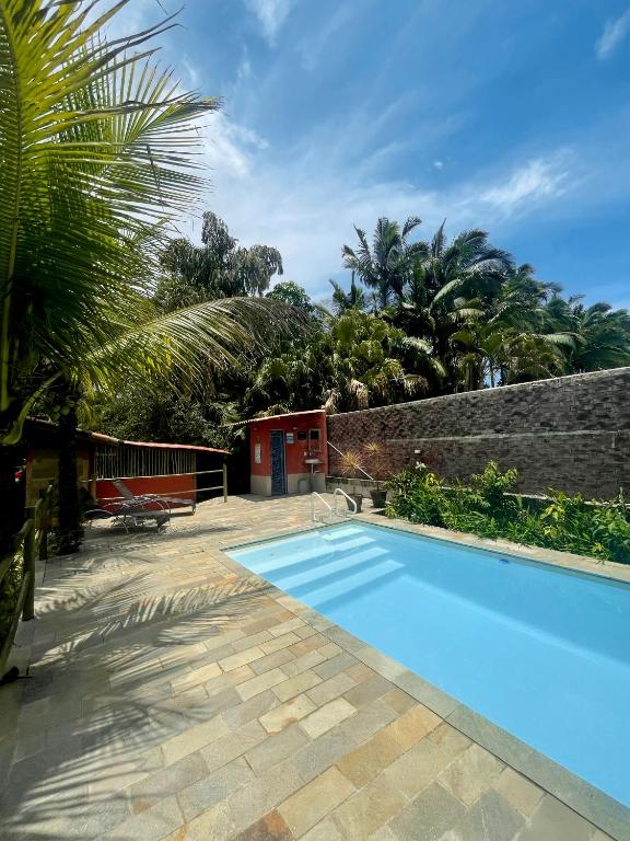 una piscina en un patio con una pared de ladrillo en Aldeia de Camburi en Camburi