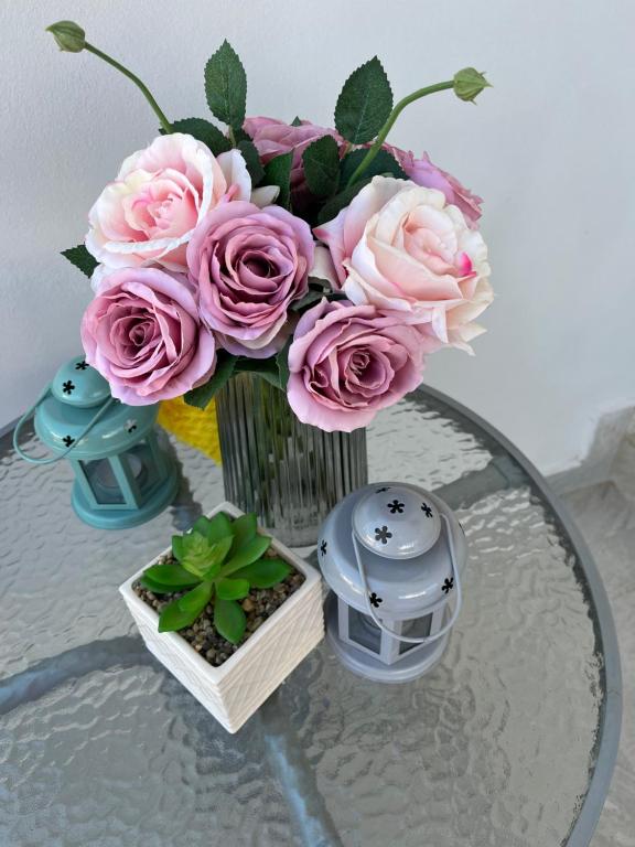 a vase filled with pink roses on a glass table at Villa Angelina Ksamil in Ksamil