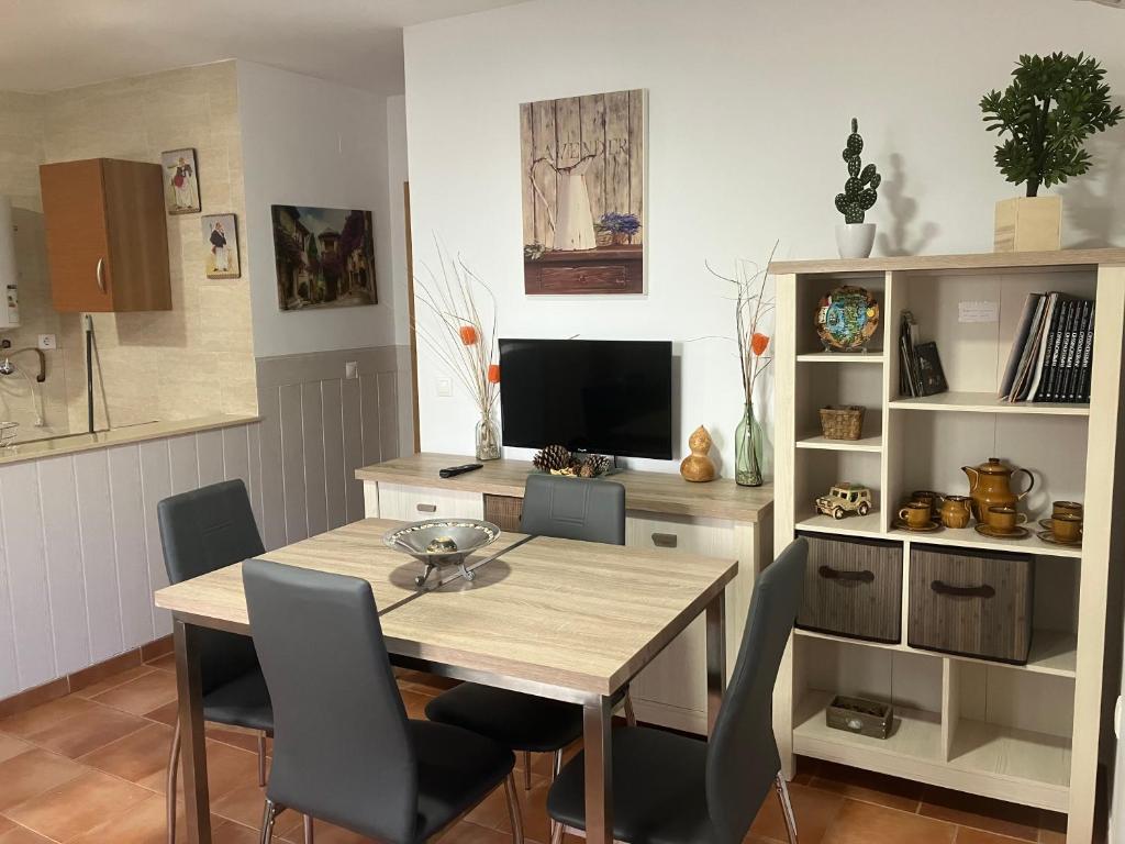 ein Esszimmer mit einem Tisch, Stühlen und einem TV in der Unterkunft Cazorla Paraíso I, Arroyo Frío in Arroyo Frio