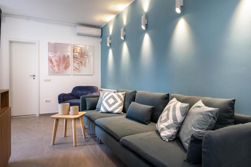 a living room with a couch and a blue wall at Sapphire Apartment In The Center Of Bucharest in Bucharest