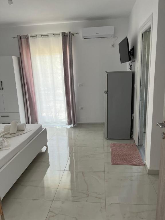 a large white room with a bed and a television at Villa Angelina Ksamil in Ksamil