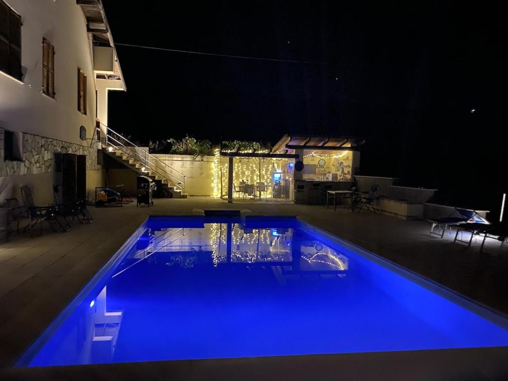 una piscina por la noche con iluminación azul en Casa Carolina - Villa/Pool with Bar, 5 bedrooms, 3 bathrooms, Great For Groups., en Castel Rocchero