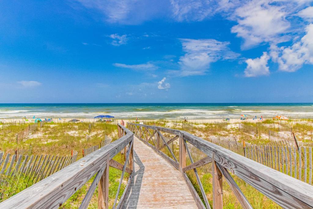 a boardwalk to the beach with the ocean in the background at Barrier Dunes Hideaway in Oak Grove