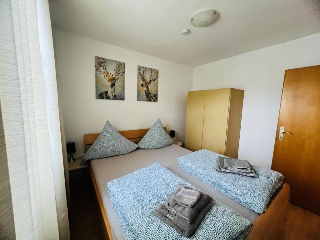 a small bedroom with two beds with blue pillows at Ferienwohung Arnstein Nr 2 in Waldeck