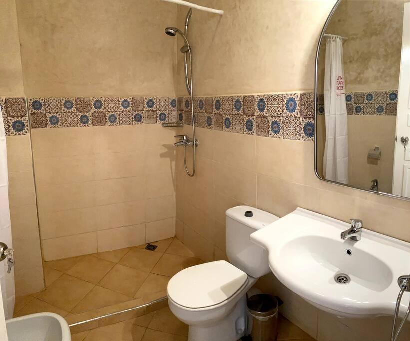 een badkamer met een toilet, een wastafel en een spiegel bij A6 MAISON BLANCHE IMI OUADDAR in Agadir