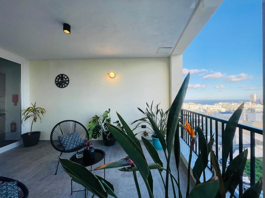 Habitación con plantas y balcón con vistas. en 190 Sqm Apartment in Swieqi with Views and free high speed Wifi, en Is-Swieqi