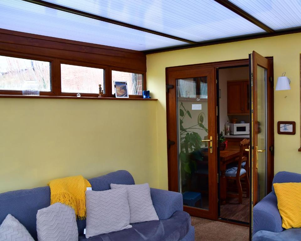 a living room with a blue couch and a table at Entire Niche in Hildenborough