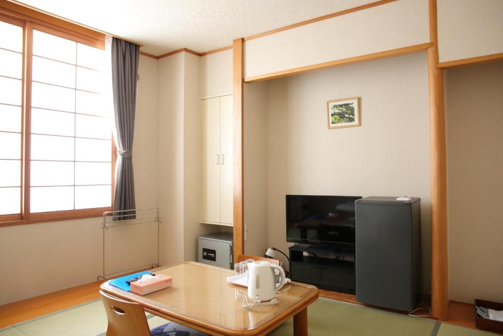 salon ze stołem i telewizorem w obiekcie Pinneshiri onsen Hotel Bogakuso - Vacation STAY 31617v w mieście Pinneshiri