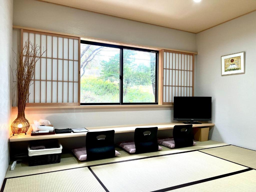 een woonkamer met 2 stoelen en een televisie bij Open House Sakurasakura - Kamakurayama - - Vacation STAY 14049 in Kamakura