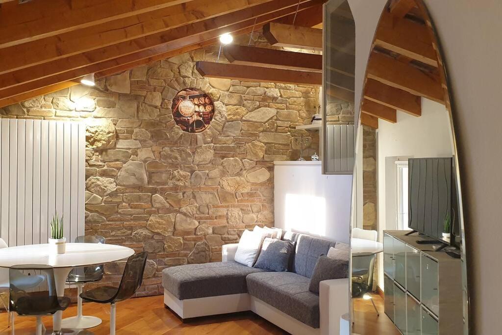 sala de estar con sofá y pared de piedra en Private Luxury, en Udine