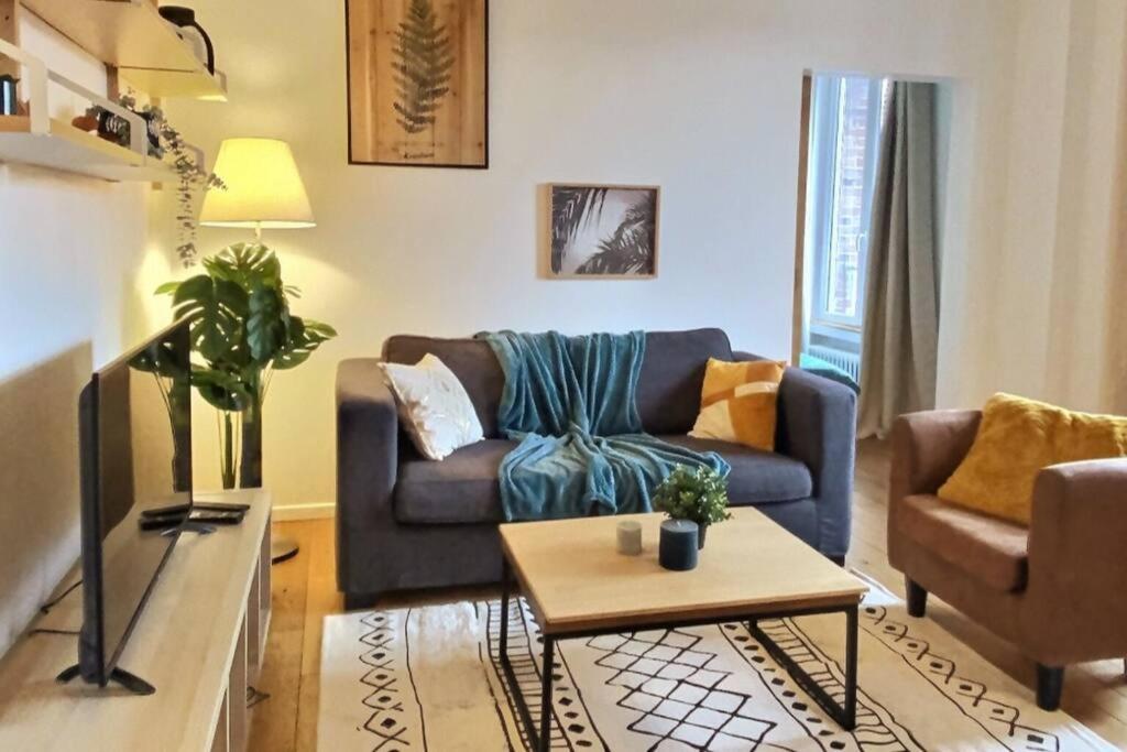 ein Wohnzimmer mit Sofa und Tisch in der Unterkunft Appartement 2 pièces à quelques minutes de Paris in Le Pré-Saint-Gervais