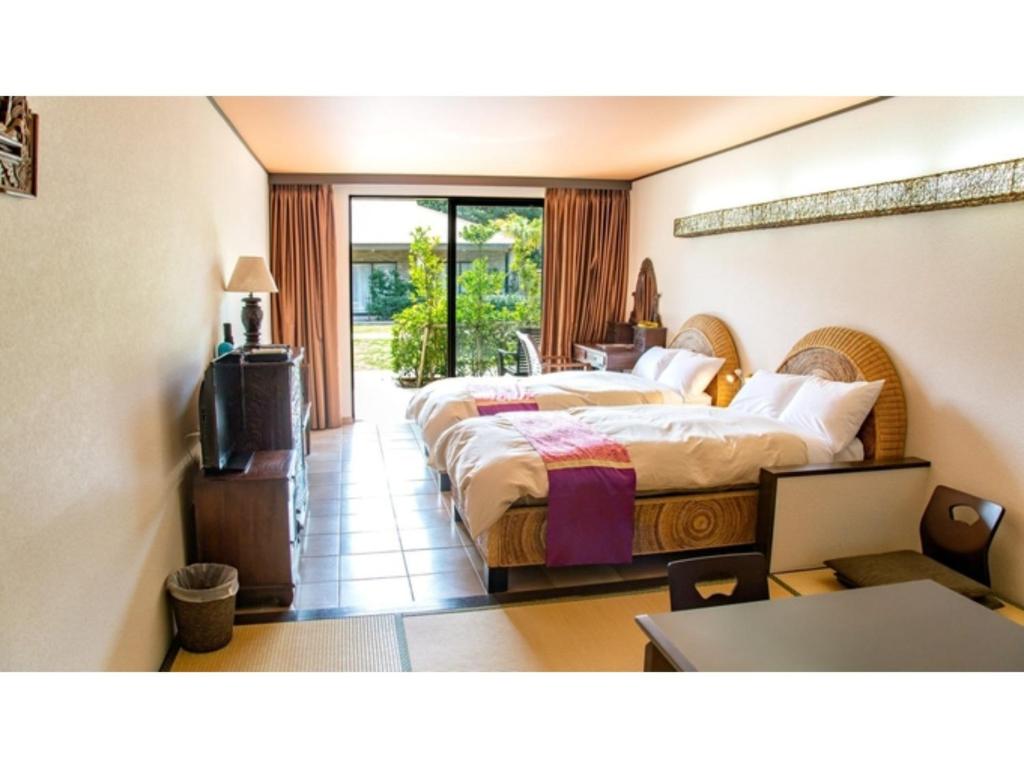 um quarto de hotel com duas camas e uma televisão em Hachijojima Hotel Resort Sea Pillows - Vacation STAY 53186v em Mitsune