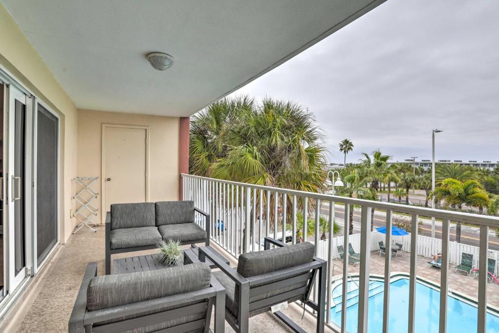 a balcony with two chairs and a swimming pool at Indian Shores Condo with 2 Balconies and Pool Access! in Clearwater Beach