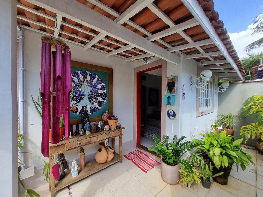 una casa con porche con plantas y techo en Casa decorada perto da Praia de Perequê - Ilhabela, en Ilhabela