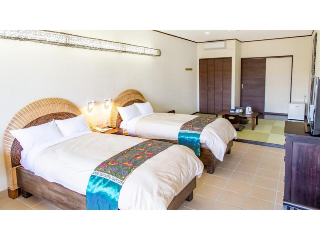 a hotel room with two beds and a television at Hachijojima Hotel Resort Sea Pillows - Vacation STAY 53313v in Mitsune
