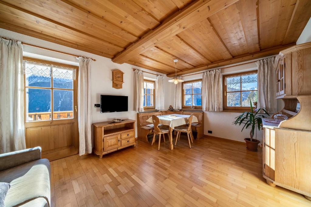 a living room with a table and a tv at Kalchgruberhof Wohnung Enzian in Ultimo