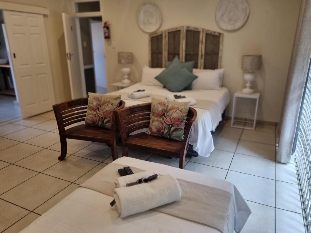 a bedroom with a bed and a table and chairs at Sha-Mani Guesthouse & Conference Venue in Alberton