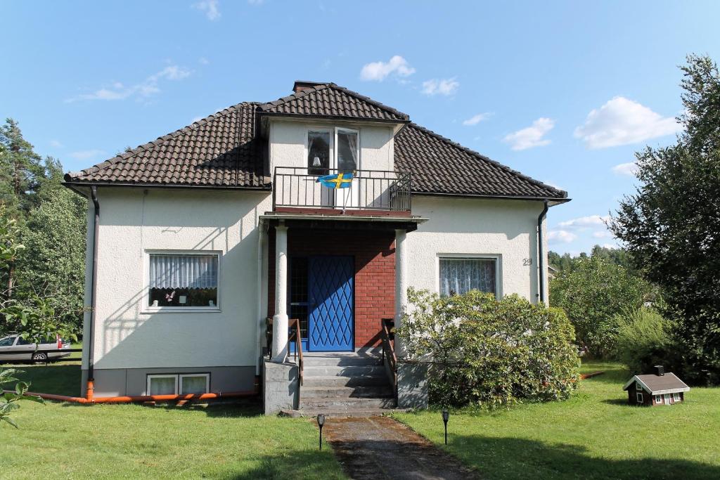 ein Haus mit einer blauen Tür und einem Balkon in der Unterkunft Ferienhaus mit Kamin in Småland für 6 Personen in Järnforsen