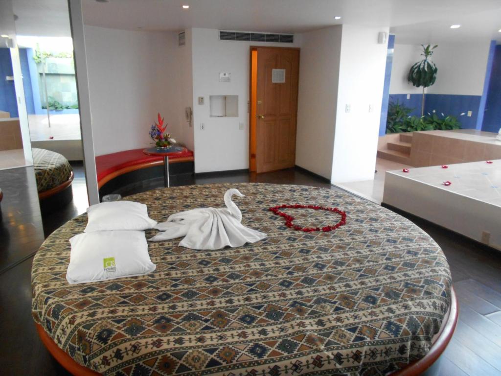 una camera con un letto con un cigno sopra di GS Cuernavaca Drive Inn - Adults Only a Cuernavaca