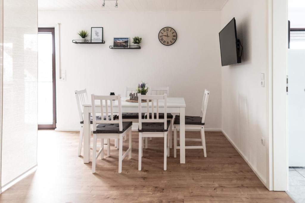 a white dining room with a white table and chairs at Eindrucksvolles Gruppen– und Monteursloft in Edingen-Neckarhausen