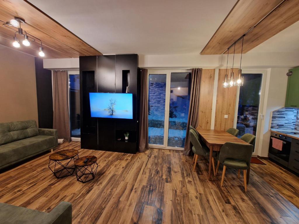 a living room with a table and a television at Mavrovo ski apartment in Mavrovo