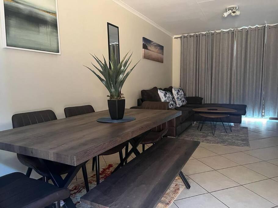 a living room with a wooden table and a couch at Centurion: Chilled Townhouse in Centurion