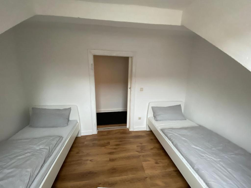 2 letti in una stanza vuota con pavimenti in legno di Apartment for rent 1 a Celle