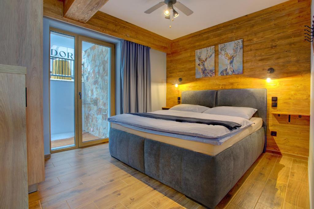 a bedroom with a large bed and a large window at Rezidence KUPEC in Frymburk