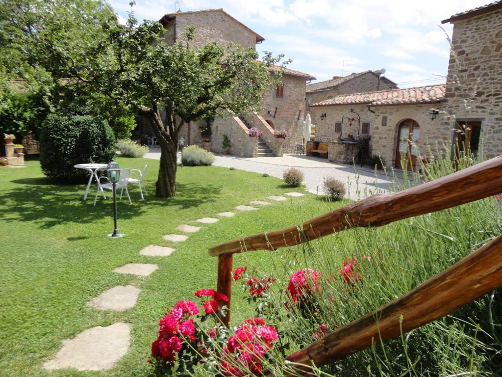 un giardino con tavolo e fiori nell'erba di Casale l'Antico Carro a Cortona