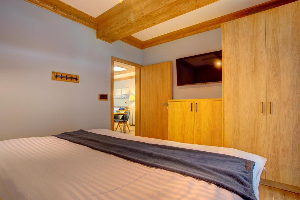 a bedroom with a bed and a flat screen tv at Rezidence KUPEC in Frymburk