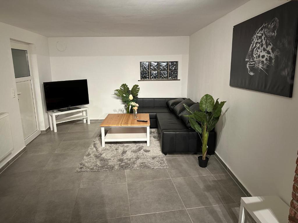 een woonkamer met een zwarte bank en een salontafel bij Apartment for rent 2 in Celle