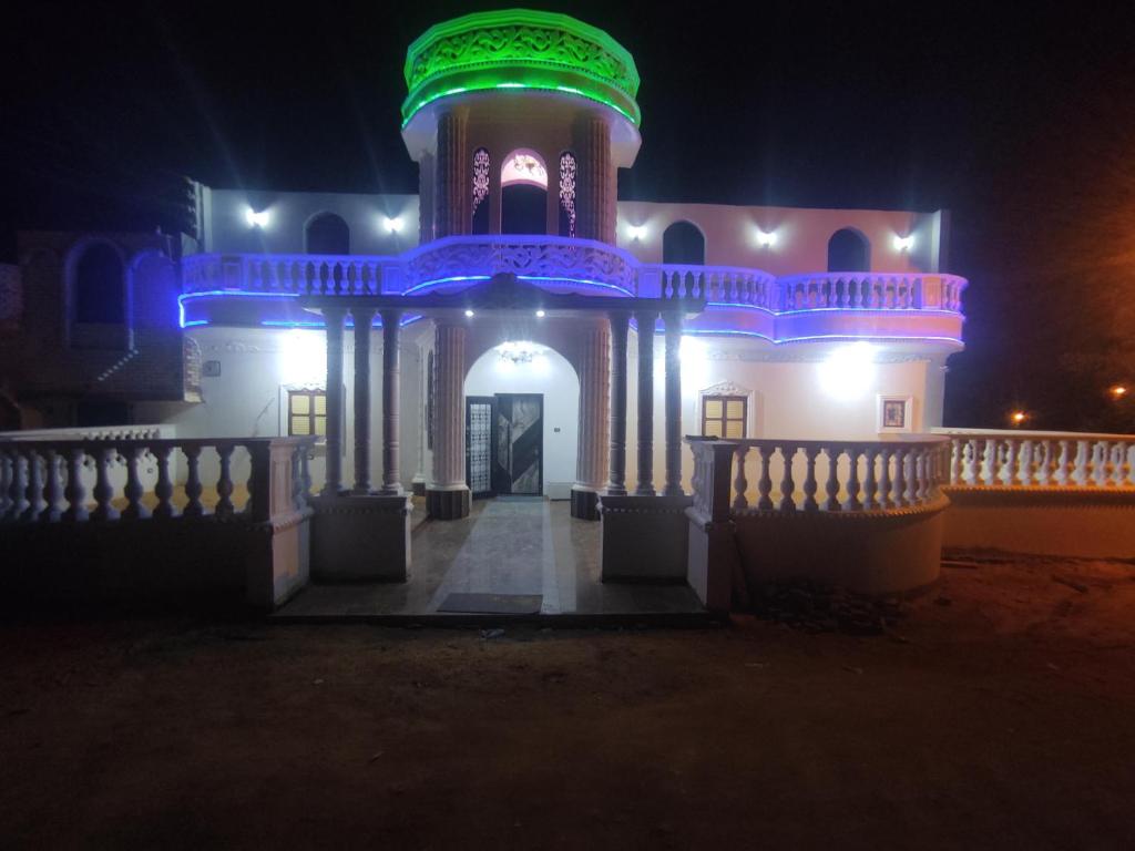a building with a lit up tower at night at The nubian white house in Aswan