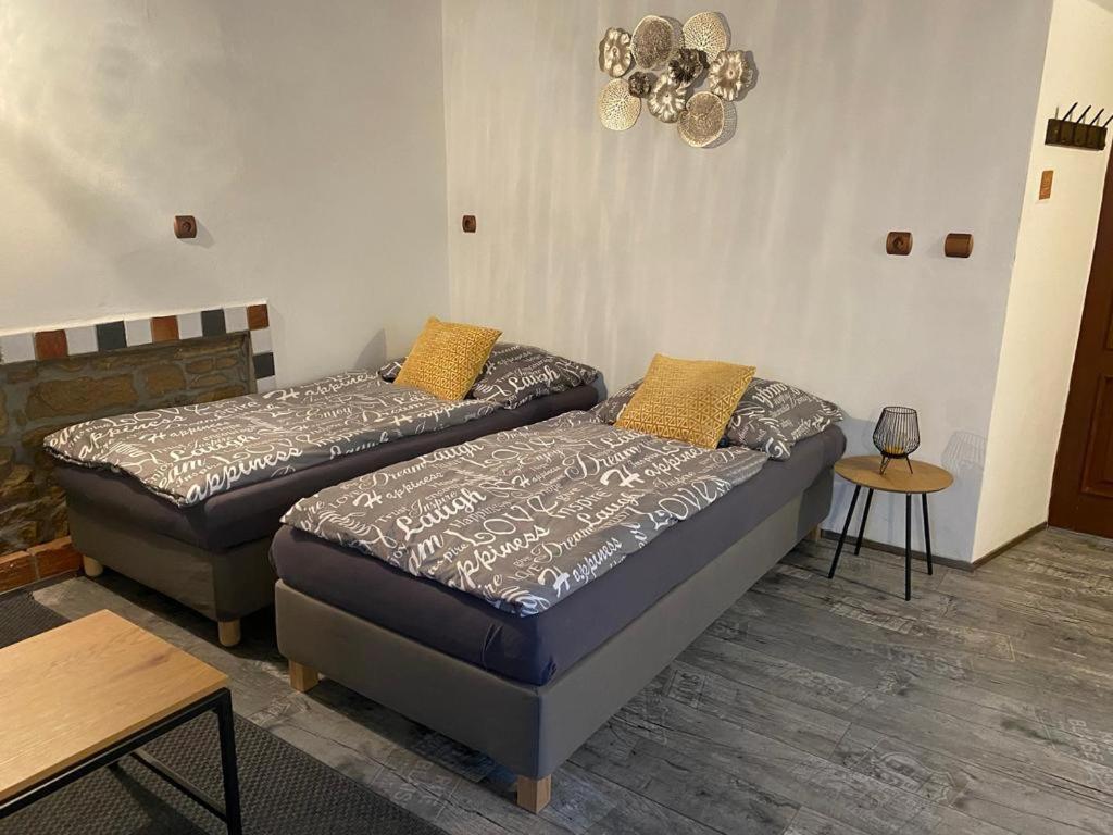 Habitación con 2 camas y mesa. en Apartmány Vila Lucia 2, en Plzeň