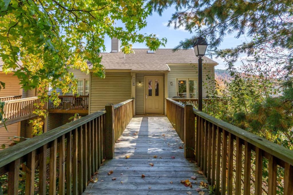 a wooden bridge leading to a house with a porch at Massanutten Resort by TripForth in McGaheysville