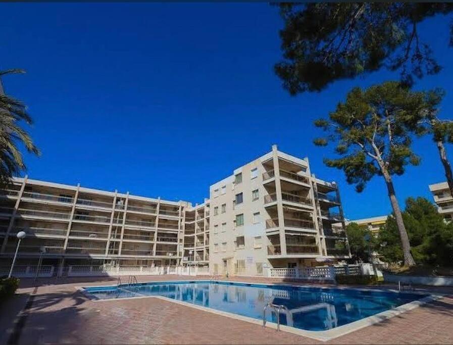 a building with a swimming pool in front of a building at Cala Dorada in Salou