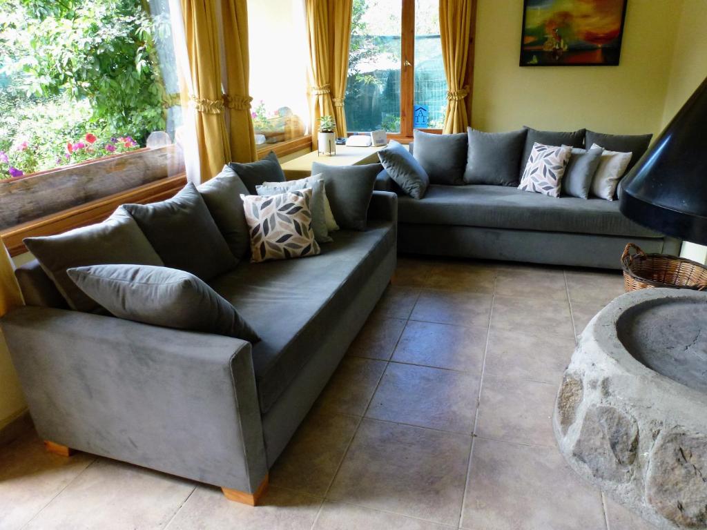 uma sala de estar com sofás e uma grande janela em Cabañas Gnionguis em Villa La Angostura