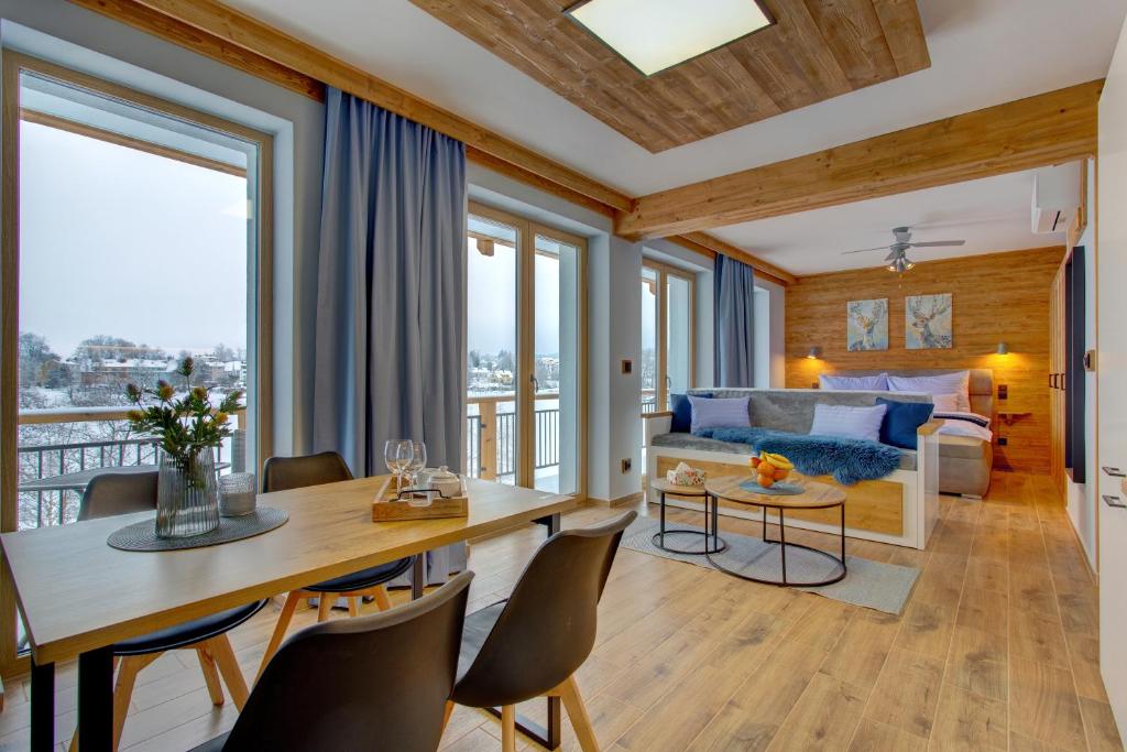 a living room with a table and chairs and a couch at Rezidence KUPEC in Frymburk