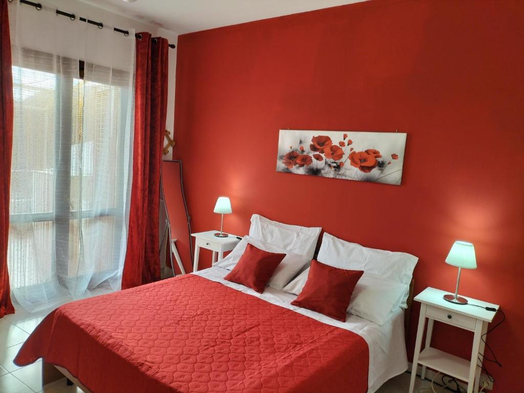 a red bedroom with a bed with a red wall at Casa Vacanza Da Rosa in Letojanni