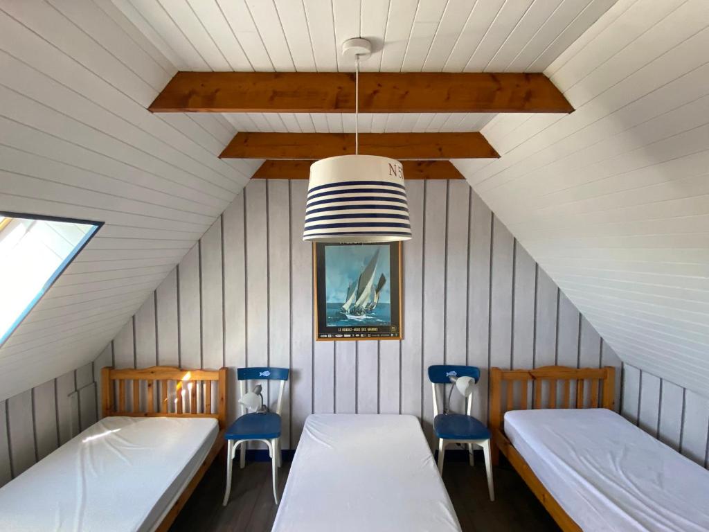 a room with two beds and two blue chairs at L'air marin in Plozévet