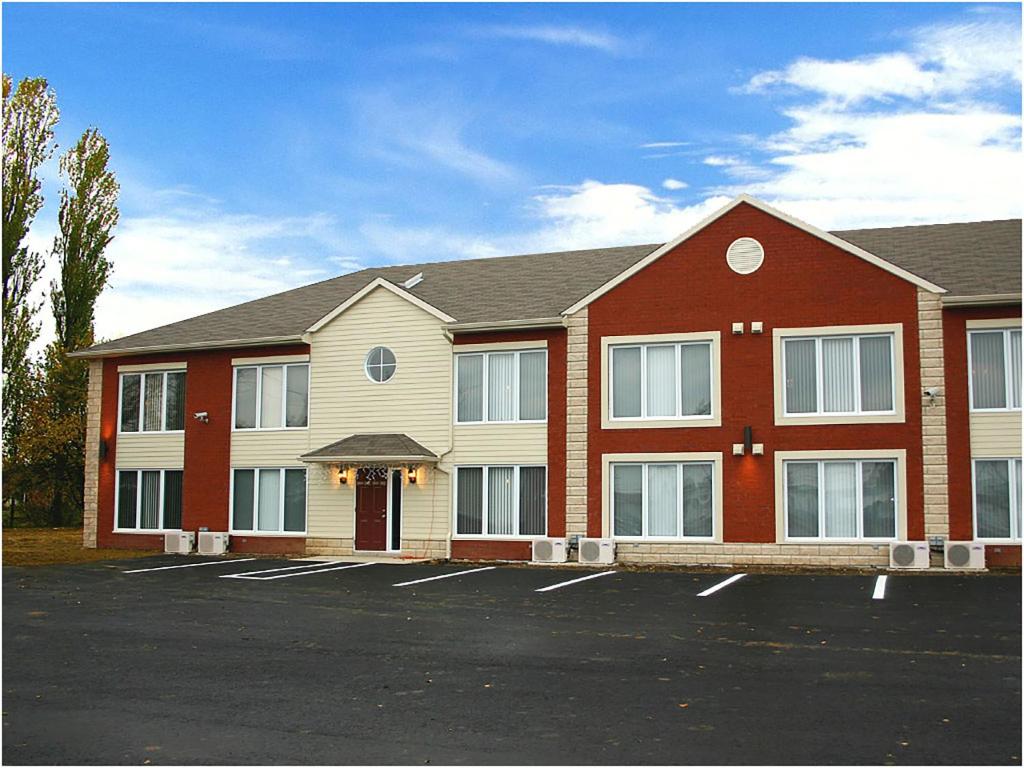 un gran edificio con un estacionamiento delante de él en Travelodge by Wyndham Drummondville, en Drummondville