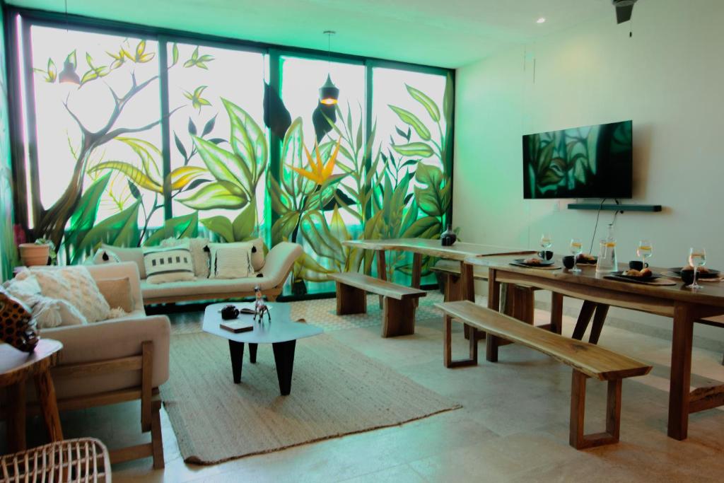 a living room with tables and a mural of plants at PH-4-Groups 3BR Priv-RoofTop 18Pax @Aldea Zama in Tulum